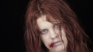 Ashley of Hollywood Noir Makeup wearing a newly infected zombie make up for Halloween.